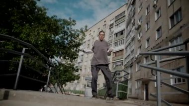 Kız şehir caddesinde serin kanlı hip-hop dansı yapıyor. Bir dansçı bir şehir evinin yakınında dans eder. Gri gömlekli kadın merdivenlerde numaralar yapıyor. Merdivenlerde gösteriş yapan kız. Merdivenlerde gri tişörtlü bir sokak sanatçısı. Gri gömlekli bir kadının merdiven numaraları..