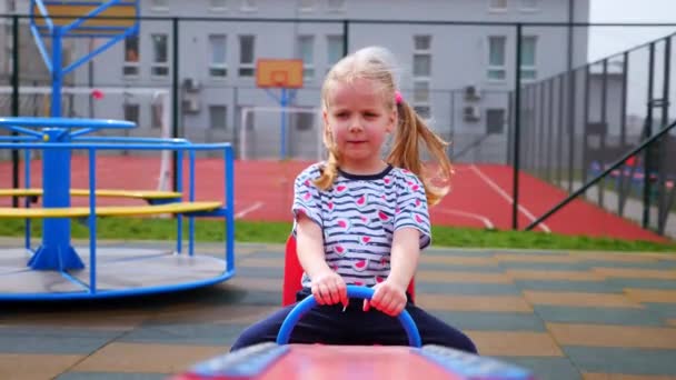 Lille Pige Svinger Rundt Legepladsen Barnet Griner Muntert Entusiastisk Attraktionen – Stock-video