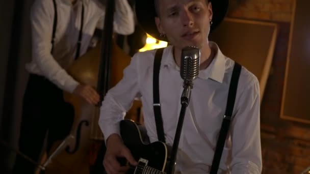 남자는 스튜디오에서 기타를 부르고 연주하고 있습니다 레스토랑에서 로맨틱 빛입니다 블루스 — 비디오