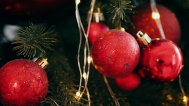 Geleneksel Noel ağacı kırmızı süslemelerle süslenmiş. Güzel dekore edilmiş Noel ağacı olan şenlik odası. Kırmızı takılar bir tatil ağacına renk katıyor. Kırmızıyla süslenmiş klasik bir Noel ağacıyla samimi bir ortam. Zarif dekorasyonlar 