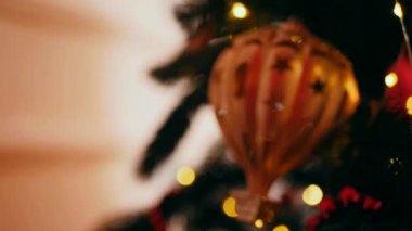 Geleneksel Noel ağacı kırmızı süslemelerle süslenmiş. Güzel dekore edilmiş Noel ağacı olan şenlik odası. Kırmızı takılar bir tatil ağacına renk katıyor. Kırmızıyla süslenmiş klasik bir Noel ağacıyla samimi bir ortam. Zarif dekorasyonlar 
