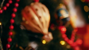 Geleneksel Noel ağacı kırmızı süslemelerle süslenmiş. Güzel dekore edilmiş Noel ağacı olan şenlik odası. Kırmızı takılar bir tatil ağacına renk katıyor. Kırmızıyla süslenmiş klasik bir Noel ağacıyla samimi bir ortam. Zarif dekorasyonlar 