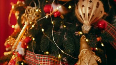 Geleneksel Noel ağacı kırmızı süslemelerle süslenmiş. Güzel dekore edilmiş Noel ağacı olan şenlik odası. Kırmızı takılar bir tatil ağacına renk katıyor. Kırmızıyla süslenmiş klasik bir Noel ağacıyla samimi bir ortam. Zarif dekorasyonlar 