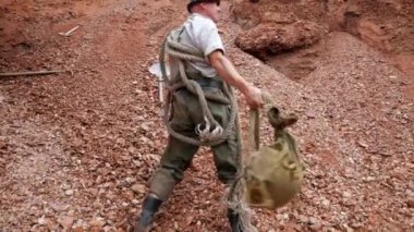 Bir adam tırmanıyor, tehlikeli bir dağa tırmanıyor. Bir adam dağlarda altın arıyor. Hazine avcısı dağlarda ve mağaralarda yürüyor. Hazine avcısı, kaşif, kazıcı. Altın arayıcısı, altın humması. Adam bir kürek, bir kürek alır ve gider. 