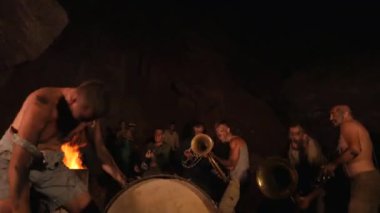 Cücelerden ve hazine avcılarından ayin dansları. Komik müzisyenler geceleri yeraltında bir mağarada çalıyorlar. Çılgın insanlar, troller, goblinler müzik aletleri çalarlar. Mağara ortamında yanıp sönen ateşin yanında duran bireylerin siluetleri..