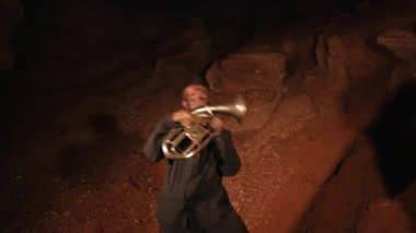 Cücelerden ve hazine avcılarından ayin dansları. Komik müzisyenler geceleri yeraltında bir mağarada çalıyorlar. Çılgın insanlar, troller, goblinler müzik aletleri çalarlar. Mağara ortamında yanıp sönen ateşin yanında duran bireylerin siluetleri..
