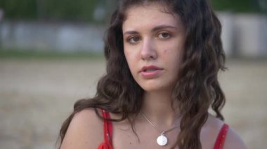 Genç bir kız model plajda dinlenir ve poz verir. Güzel kırmızı elbise. Seksi kız kendine sarılıyor, hayaller kuruyor. Kadın nehrin ve büyük evin arka planında duruyor. Model kameraya seksi bir bakışla bakıyor. Güzel nehir kıyısı ve... 