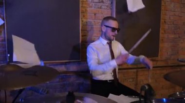 Davul çalan adam. Davulcu. Komik iş adamları müzik enstrümanları çalar. Konser veren ofis çalışanları tarzında bir rock grubu. Stüdyoda akordeon, gitar ve davul çalan bir grup adam. Kravatlı ve ceketli adamlar, takım elbiseliler eğleniyor.
