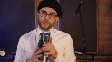 Retro mikrofona şarkı söyleyen adam. Komik iş adamları müzik enstrümanları çalar. Konser veren ofis çalışanları tarzında bir rock grubu. Stüdyoda akordeon, gitar ve davul çalan bir grup adam. Erkekler müzik stüdyosunda eğleniyor..
