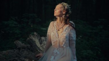 Çekici Dryad veya orman perisi. Ormanda şeffaf beyaz elbiseli hoş bir kadın. Mavka, Naiad, Nymph. Düğün kıyafetiyle bir ormanlık alanda gezinen bir gelinin büyüleyici bir sahnesi. Sihirli bir ormanda gezinen bir kadın