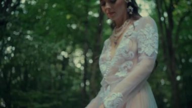 Çekici Dryad veya orman perisi. Ormanda şeffaf beyaz elbiseli hoş bir kadın. Mavka, Naiad, Nymph. Düğün kıyafetiyle bir ormanlık alanda gezinen bir gelinin büyüleyici bir sahnesi. Sihirli bir ormanda gezinen bir kadın