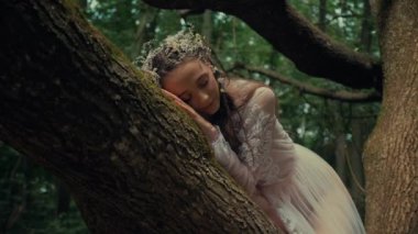 Çekici Dryad veya orman perisi. Ormanda şeffaf beyaz elbiseli hoş bir kadın. Mavka, Naiad, Nymph. Düğün kıyafetiyle bir ormanlık alanda gezinen bir gelinin büyüleyici bir sahnesi. Sihirli bir ormanda gezinen bir kadın