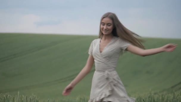 흐르는 드레스를 여자는 햇볕이 초원에서 우아하게 회전합니다 밭에서 자유롭게 여자의 — 비디오