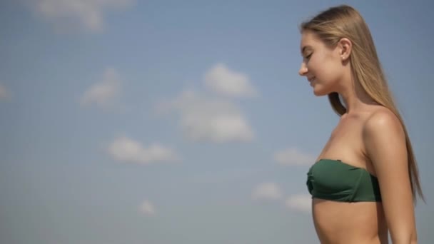 해변에서 비키니에 엉덩이를 소녀는 해변에서 일광욕입니다 매력적인 모델은 카메라에 해변에서 — 비디오