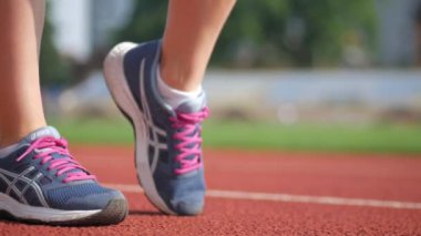 Stadyumda koşu yapan bayan sporcu. Güneşli bir günde stadyumda fiziksel egzersiz yapan ve spor yapan bayan sporcu. Spor salonunda kadın koşucu eğitimi. Dairesel stadyum pistinde koşan bir kadın. Stadyumda koşan bir kadın.