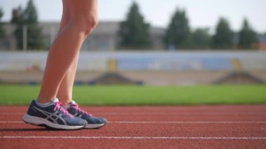 Stadyumda koşu yapan bayan sporcu. Güneşli bir günde stadyumda fiziksel egzersiz yapan ve spor yapan bayan sporcu. Spor salonunda kadın koşucu eğitimi. Dairesel stadyum pistinde koşan bir kadın. Stadyumda koşan bir kadın.