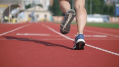 Stadyumda koşu yapan bayan sporcu. Güneşli bir günde stadyumda fiziksel egzersiz yapan ve spor yapan bayan sporcu. Spor salonunda kadın koşucu eğitimi. Dairesel stadyum pistinde koşan bir kadın. Stadyumda koşan bir kadın.