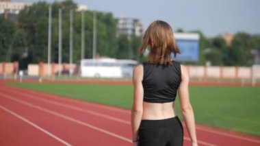 Stadyumda koşu yapan bayan sporcu. Güneşli bir günde stadyumda fiziksel egzersiz yapan ve spor yapan bayan sporcu. Spor salonunda kadın koşucu eğitimi. Dairesel stadyum pistinde koşan bir kadın. Stadyumda koşan bir kadın.