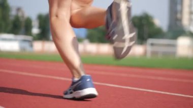 Stadyumda koşu yapan bayan sporcu. Güneşli bir günde stadyumda fiziksel egzersiz yapan ve spor yapan bayan sporcu. Spor salonunda kadın koşucu eğitimi. Dairesel stadyum pistinde koşan bir kadın. Stadyumda koşan bir kadın.