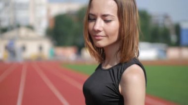 Stadyumda koşu yapan bayan sporcu. Güneşli bir günde stadyumda fiziksel egzersiz yapan ve spor yapan bayan sporcu. Spor salonunda kadın koşucu eğitimi. Dairesel stadyum pistinde koşan bir kadın. Stadyumda koşan bir kadın.