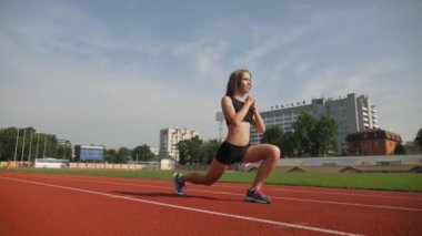 Stadyumda koşu yapan bayan sporcu. Güneşli bir günde stadyumda fiziksel egzersiz yapan ve spor yapan bayan sporcu. Spor salonunda kadın koşucu eğitimi. Dairesel stadyum pistinde koşan bir kadın. Stadyumda koşan bir kadın.