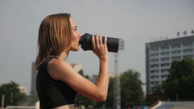 Stadyumda koşu yapan bayan sporcu. Güneşli bir günde stadyumda fiziksel egzersiz yapan ve spor yapan bayan sporcu. Spor salonunda kadın koşucu eğitimi. Dairesel stadyum pistinde koşan bir kadın. Stadyumda koşan bir kadın.
