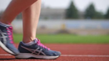 Stadyumda koşu yapan bayan sporcu. Güneşli bir günde stadyumda fiziksel egzersiz yapan ve spor yapan bayan sporcu. Spor salonunda kadın koşucu eğitimi. Dairesel stadyum pistinde koşan bir kadın. Stadyumda koşan bir kadın.