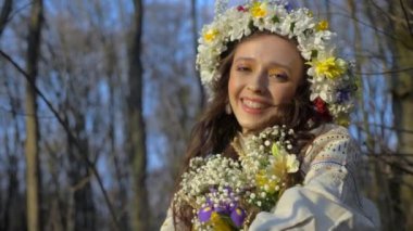 Beyaz elbiseli kadın ağaçlarla çevrili. Çiçek çelenkli kız ormanda yürüyor. Antik Ukrayna nakışlı elbisesi. Ormanlık alanda duran zarif bir kadın. Orman yaprakları arasında beyaz elbiseli bir kadın. Doğanın ortasında beyaz elbiseli güzel bir kadın.