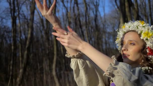 나무로 둘러싸인 드레스를 화환에있는 소녀는 숲에서 우크라이나어 드레스 우아한 사이에 — 비디오