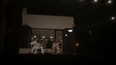 Gece gökyüzünün altında bir müzisyen ikilisi çalıyor. Bir adam keman çalar ve bir kız gece sokakta bir konserde şarkı söyler. Müzisyenler restoranın sahnesinde çalarlar..