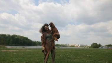 Mutlu kadın ve tüylü arkadaşı parkta güneşli bir günün tadını çıkarıyorlar. Parkta neşeli kahverengi bir köpek olan Cocker Spaniel ile etkileşime giren bir kadın. Gülümseyen kadın, açık havada dost canlısı kahverengi bir köpeği okşuyor. Bir kadın ve kahverengi köpeği arasında sakin bir an.