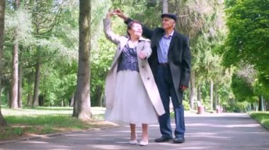 Yaşlı bir çift parkta huzur içinde geziniyor. Bir erkek ve bir kadın doğanın içinde sakin bir şekilde yürüyorlar. Parkta gezinen yaşlı bir çift. Daha yaşlı bir çift, sakin bir park ortamında oynaşıyor. Bir beyefendi ve bir bayan yürüyor.