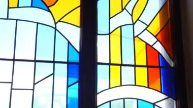 Renkli vitray pencere ve kilisede karmaşık tasarımlar. Süslü cam pencereden süzülen güneş ışığı. Parlak vitraylı camlarda dini figürlerin betimlenmesi. Kilise ortamında titizlikle hazırlanmış vitray sanat eserleri..