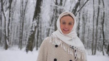 Beyaz atkı ve paltolu kadın karlı ormanda duruyor. Karla kaplı ormanda duran bir kadın. Kış sahnesinde beyaz önlüklü bir kadın kış ormanında yürüyor. Karlı orman manzarasında bir kadın. Beyaz önlüklü bir kadınla karlı orman arkaplanı. 