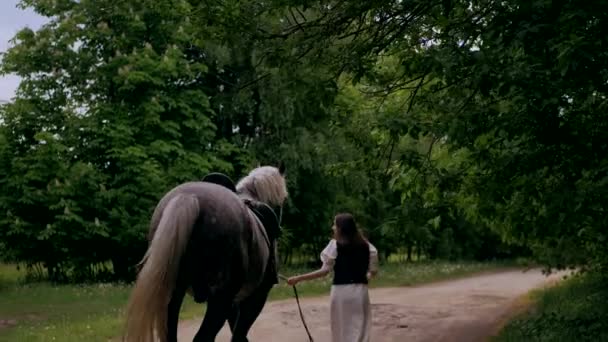 Γυναίκα Χαϊδεύει Απαλά Άλογο Ένα Ήσυχο Δάσος Γαλήνια Στιγμή Καθώς — Αρχείο Βίντεο