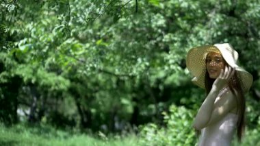 Bahçedeki ağaçların arasında duran pembe elbiseli ve hasır şapkalı kız. Park ortamında gülümseyen pembe elbiseli genç bir kız. Ormanda ağaçlarla çevrili pembe elbiseli bir kız. Pembe elbiseli kız yemyeşil ormanda dikiliyor.. 