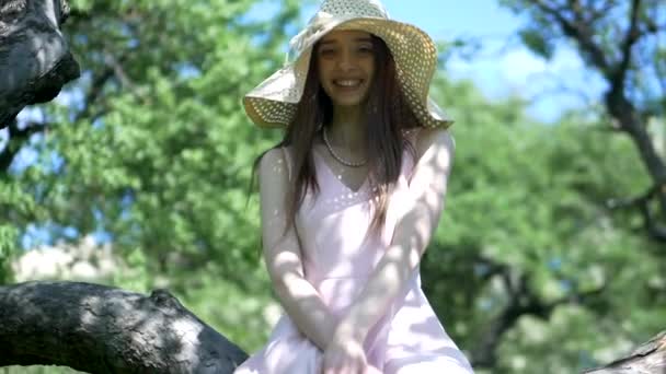 Dziewczyna Różowej Sukience Słomy Kapelusz Stojący Wśród Drzew Ogrodzie Młoda — Wideo stockowe