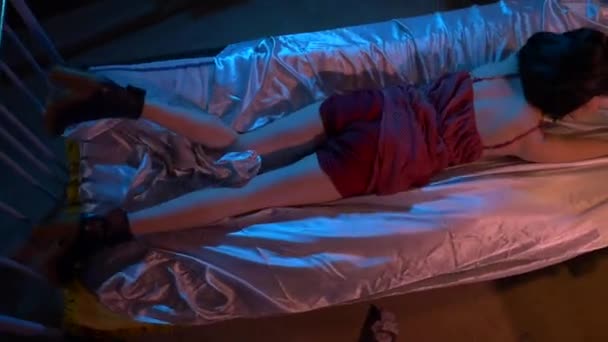 가운을 여자는 침대에서 휴식을 취합니다 어두운 방에서 침대에 드레스에 낭만적 — 비디오