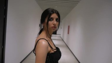 Siyah elbiseli zarif bir kadın koridorda yürüyor. Siyah elbiseli şık bir bayan koridorda yürüyor. Siyah elbiseli bir kadın koridorda ilerlerken zarafet saçıyor. Siyah giyinmiş kadın zarif bir şekilde koridorda geziniyor.. 