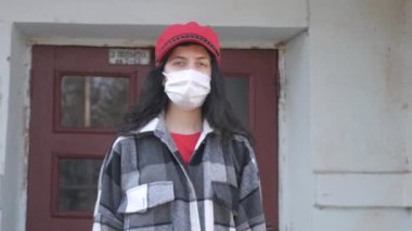 Issız bir şehirde tıbbi koruyucu maskeli yalnız bir kadın. Şehirde virüs salgını var. Coronavirus. Dünyada tehlikeli bir hastalığın salgını.