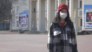 Issız bir şehirde tıbbi koruyucu maskeli yalnız bir kadın. Şehirde virüs salgını var. Coronavirus. Dünyada tehlikeli bir hastalığın salgını.