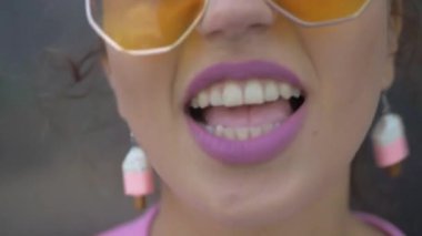 Tuhaf pembe elbiseli bir kadın binanın önünde neşeyle şarkı söylüyor. Pembe elbiseli canlı bir kadın bir binanın yakınında dans figürleri sergiliyor. Pembe ceketli ve şortlu biri bir binanın yanında enerjik bir şekilde şarkı söylüyor. Pembe elbiseli, neşeli bir kadın. 