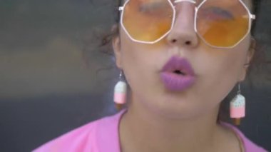Tuhaf pembe elbiseli bir kadın binanın önünde neşeyle şarkı söylüyor. Pembe elbiseli canlı bir kadın bir binanın yakınında dans figürleri sergiliyor. Pembe ceketli ve şortlu biri bir binanın yanında enerjik bir şekilde şarkı söylüyor. Pembe elbiseli, neşeli bir kadın. 