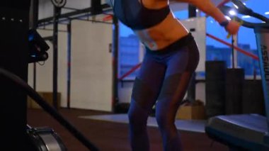 Beden eğitiminde fiziksel egzersiz yapan bir kadın. Kadın spor salonunda ağırlıklı çömelme yapıyor. Aktif bayan spor salonunda dambıllarla çömeliyor. Kadın bacak egzersizi için çömeliyor. Spor meraklısı düzgün bir şekilde çömeliyor. Sportif Kadın  