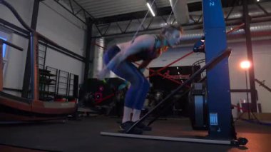 Beden eğitiminde fiziksel egzersiz yapan bir kadın. Kadın spor salonunda ağırlıklı çömelme yapıyor. Aktif bayan spor salonunda dambıllarla çömeliyor. Kadın bacak egzersizi için çömeliyor. Spor meraklısı düzgün bir şekilde çömeliyor. Sportif Kadın  