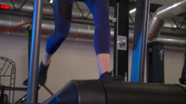 Beden eğitiminde fiziksel egzersiz yapan bir kadın. Kadın spor salonunda ağırlıklı çömelme yapıyor. Aktif bayan spor salonunda dambıllarla çömeliyor. Kadın bacak egzersizi için çömeliyor. Spor meraklısı düzgün bir şekilde çömeliyor. Sportif Kadın  