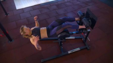 Beden eğitiminde fiziksel egzersiz yapan bir kadın. Kadın spor salonunda ağırlıklı çömelme yapıyor. Aktif bayan spor salonunda dambıllarla çömeliyor. Kadın bacak egzersizi için çömeliyor. Spor meraklısı düzgün bir şekilde çömeliyor. Sportif Kadın  
