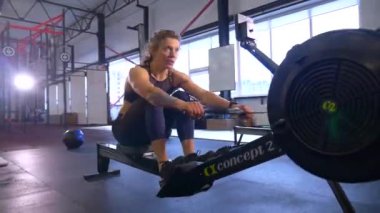 Beden eğitiminde fiziksel egzersiz yapan bir kadın. Kadın spor salonunda ağırlıklı çömelme yapıyor. Aktif bayan spor salonunda dambıllarla çömeliyor. Kadın bacak egzersizi için çömeliyor. Spor meraklısı düzgün bir şekilde çömeliyor. Sportif Kadın  