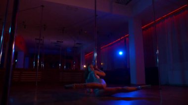 Seksi kadın disko kulübünde direk dansı yapıyor. Direğin üstünde erotik dans. Egzotik direk dansı, striptizci, direk sporu, direk sanatı. Dansçı bir direğin etrafında kıvrılır ve döner. Baştan çıkarıcı striptizci akışkan hareketleriyle gölgelerde büyülenir..