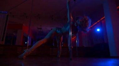 Seksi kadın disko kulübünde direk dansı yapıyor. Direğin üstünde erotik dans. Egzotik direk dansı, striptizci, direk sporu, direk sanatı. Dansçı bir direğin etrafında kıvrılır ve döner. Baştan çıkarıcı striptizci akışkan hareketleriyle gölgelerde büyülenir..